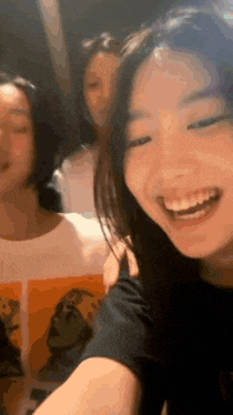 a group of young women are standing next to each other and smiling for the camera .