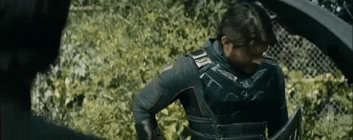 a man in a superhero costume is standing next to a man in a superhero costume .