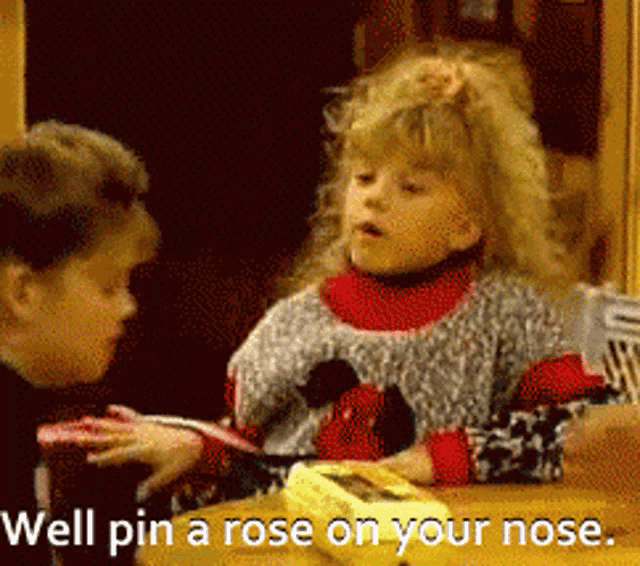 a girl sitting at a table with the words well pin a rose on your nose on the bottom