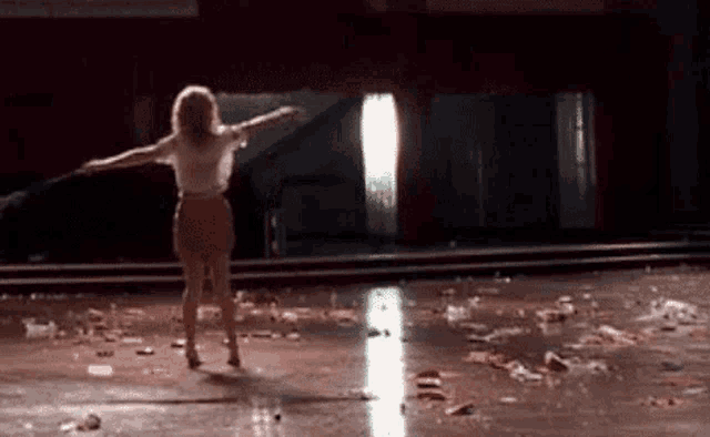 a woman is dancing on a messy dance floor in a room .