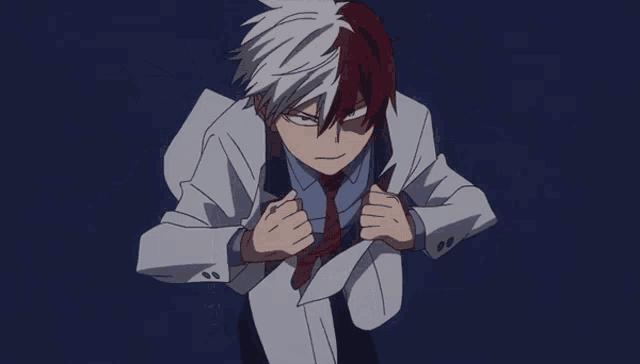 a man in a blue shirt and red tie is standing in the dark
