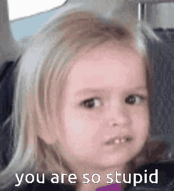 a little girl is making a funny face while sitting in a car seat .