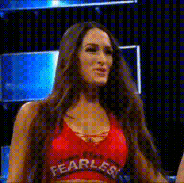 a woman is wearing a red top that says `` fearless '' on it .