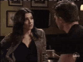a man in a black shirt is talking to a woman on a abc television show