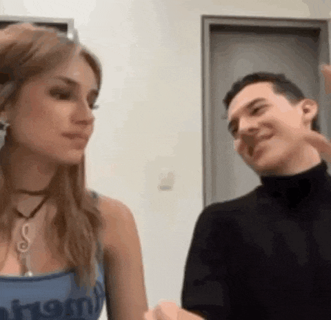 a man and a woman are standing next to each other and talking to each other .