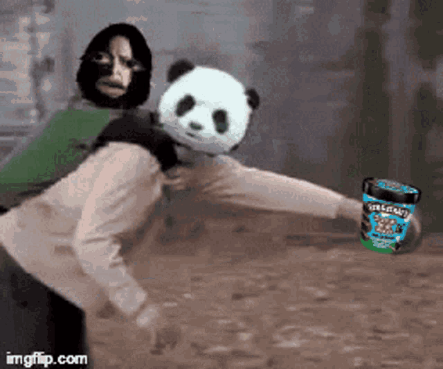 a person wearing a panda mask is holding a container of ice cream