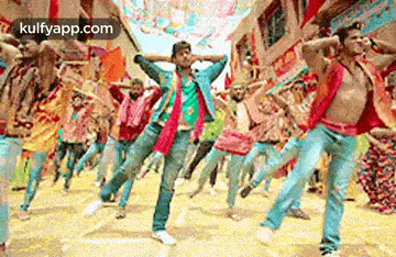 a group of people are dancing on a street in a crowd .