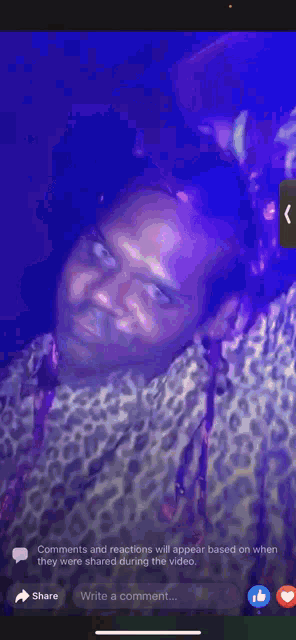 a man in a leopard print shirt is holding a microphone in front of his face