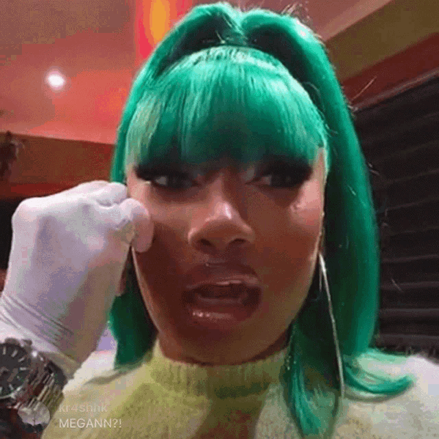 a woman with green hair is being punched in the face by someone wearing white gloves