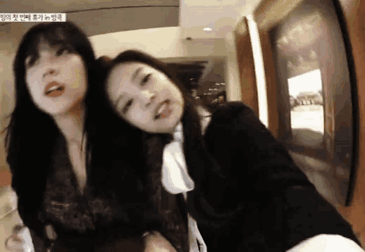 two women are posing for a picture and one of them is sticking out her tongue .