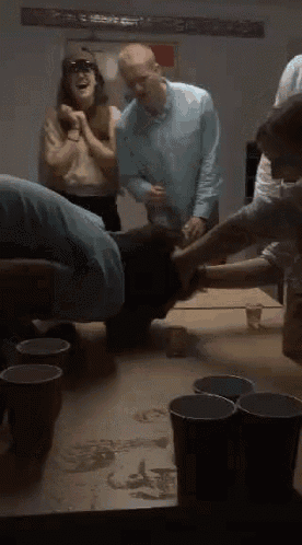 a group of people are playing a game of beer pong with red cups