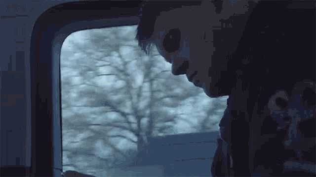a man is looking out a window with a sticker on his shirt that says ' ss ' on it
