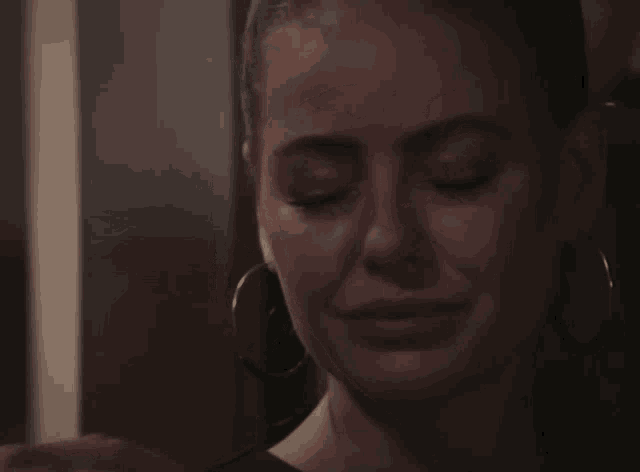 a close up of a woman 's face with tears coming out of her eyes