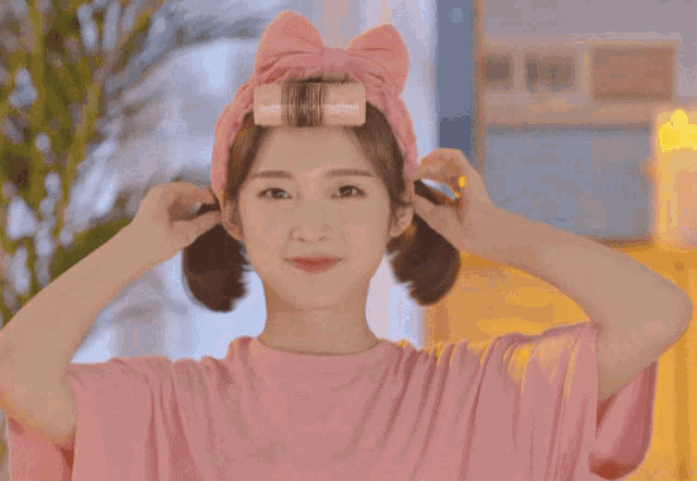a woman wearing a pink headband with a bow on it is smiling