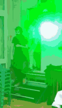 a person standing on a set of stairs in front of a green light