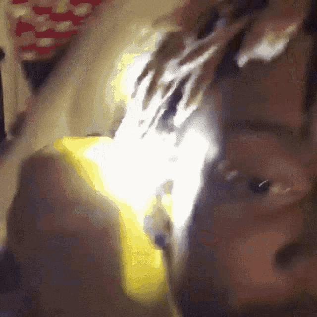 a close up of a person 's face with a yellow light shining through it