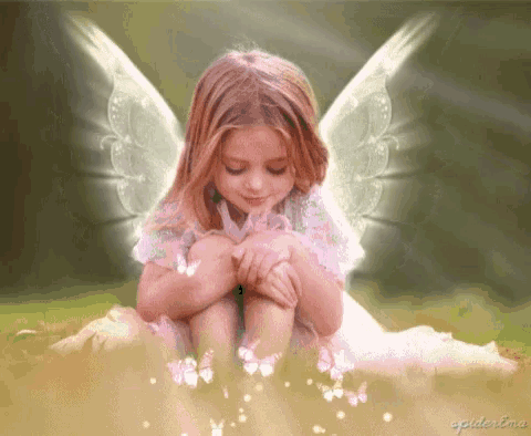 a little girl with angel wings is sitting on the ground