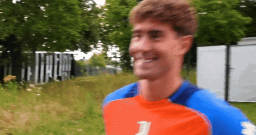 a man wearing a blue and orange shirt with the number 2 on it