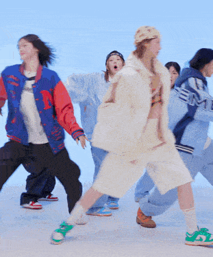a group of people are dancing and one of them is wearing a jacket that says eme