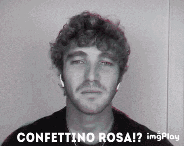 a man with curly hair and a beard is wearing ear buds and the words confettino rosa