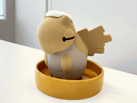 a brown and white bird with wings is sitting in a yellow bowl