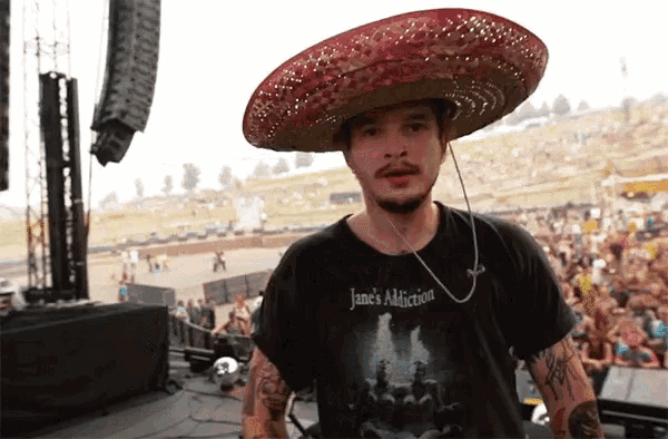 a man wearing a sombrero is wearing a jane 's addiction shirt