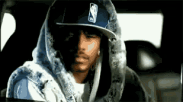 a man wearing a hoodie and a hat is sitting in a car .