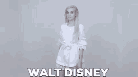 a woman in a white dress is standing in front of a walt disney logo .
