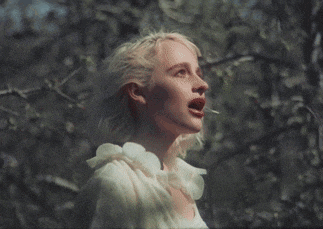 a woman in a white dress is looking up at the sky