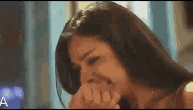 a woman is covering her face with her hand while crying .