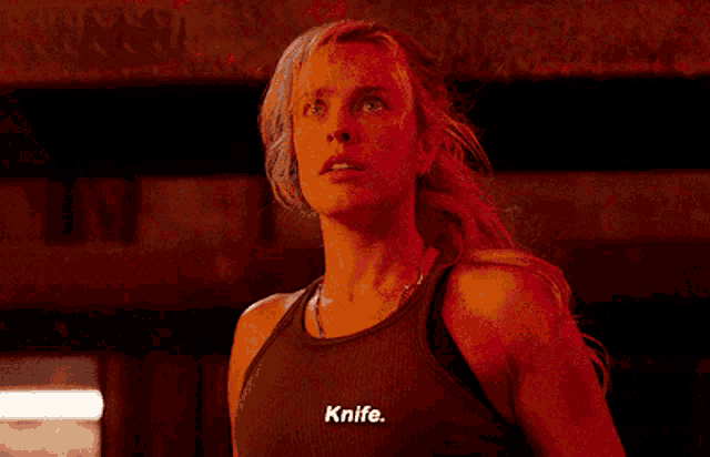 a woman wearing a tank top that says knife