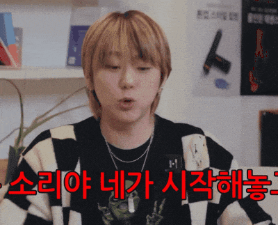 a man wearing a black and white checkered sweater has korean writing on his shirt