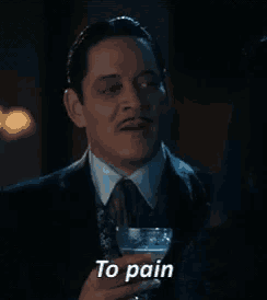 a man in a suit and tie is holding a glass with the words to pain written on it