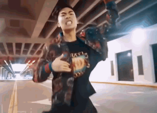a young man wearing a gucci shirt is dancing in a parking lot .