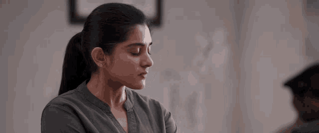 a woman with her eyes closed and a ponytail