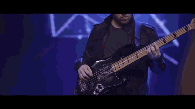 a man in a black shirt is playing drums in a dark room