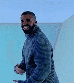 a man with a beard is wearing a blue sweater and smiling