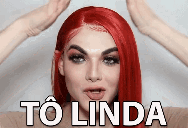 a woman with red hair is wearing a wig and has the word to linda on her face .