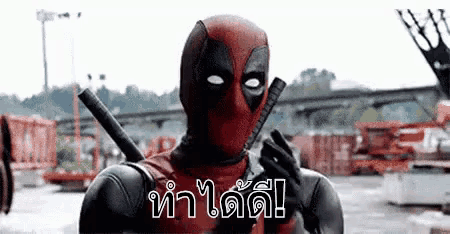 a man in a deadpool costume is holding a sword in his hand .