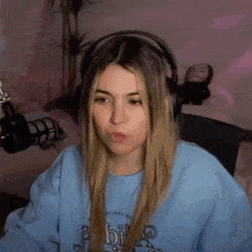 a woman wearing headphones is sitting in front of a microphone in a room .