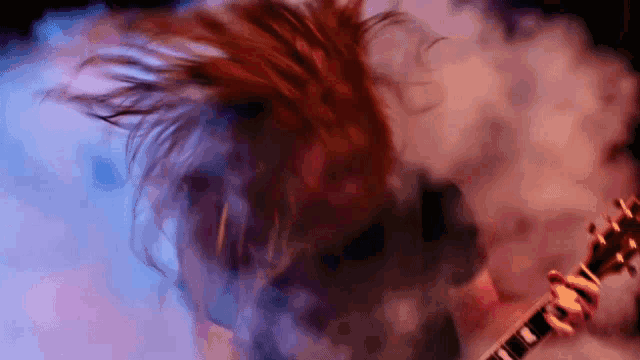 a close up of a person playing an electric guitar with smoke coming out of it