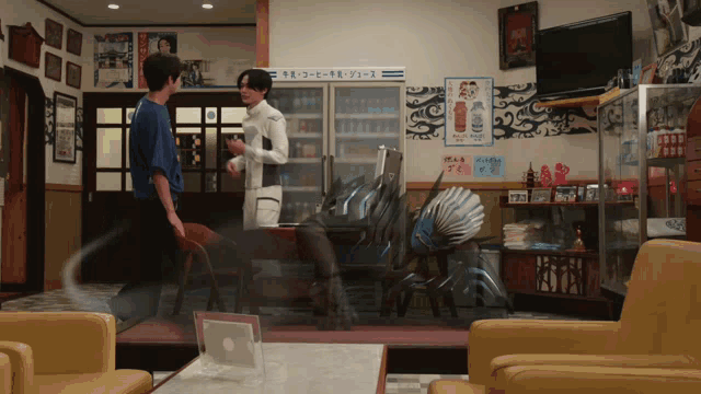 two men are standing in a room with a sign on the wall that says ' a '
