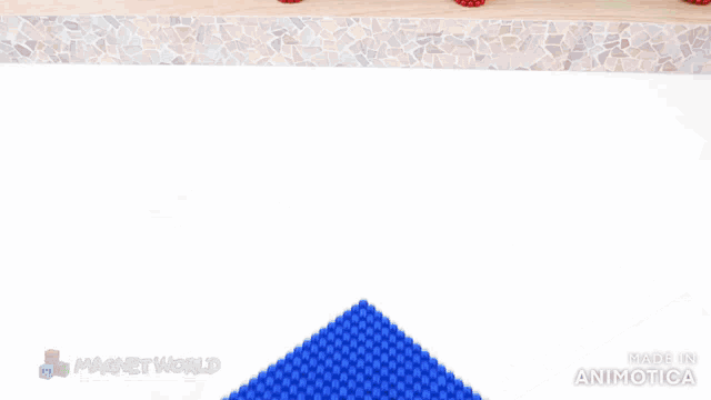 a person is holding a piece of green and a piece of blue magnet world