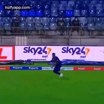 a man is running on a soccer field in front of a sky24 banner