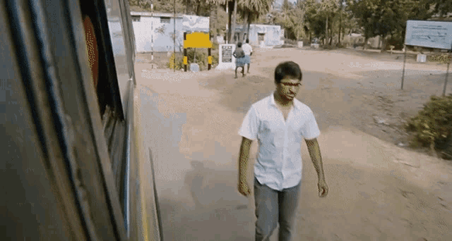 a man in a white shirt is walking down the street