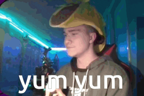 a man wearing a yellow hat is holding a light saber and the words yum yum are above him