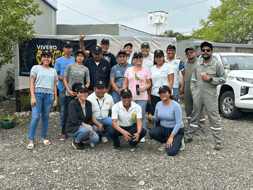 a group of people posing for a picture in front of a vivero sign