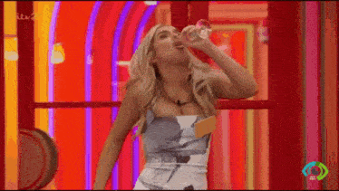 a woman in a dress is drinking water from a glass .