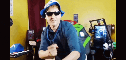 a man wearing a hat and sunglasses is dancing