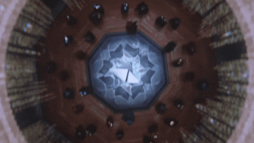 a group of people are gathered in a dark room with a clock in the center